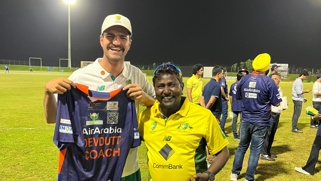 Liam and his fellow cricketers on the field. Liam is holding a coach’s shirt.
