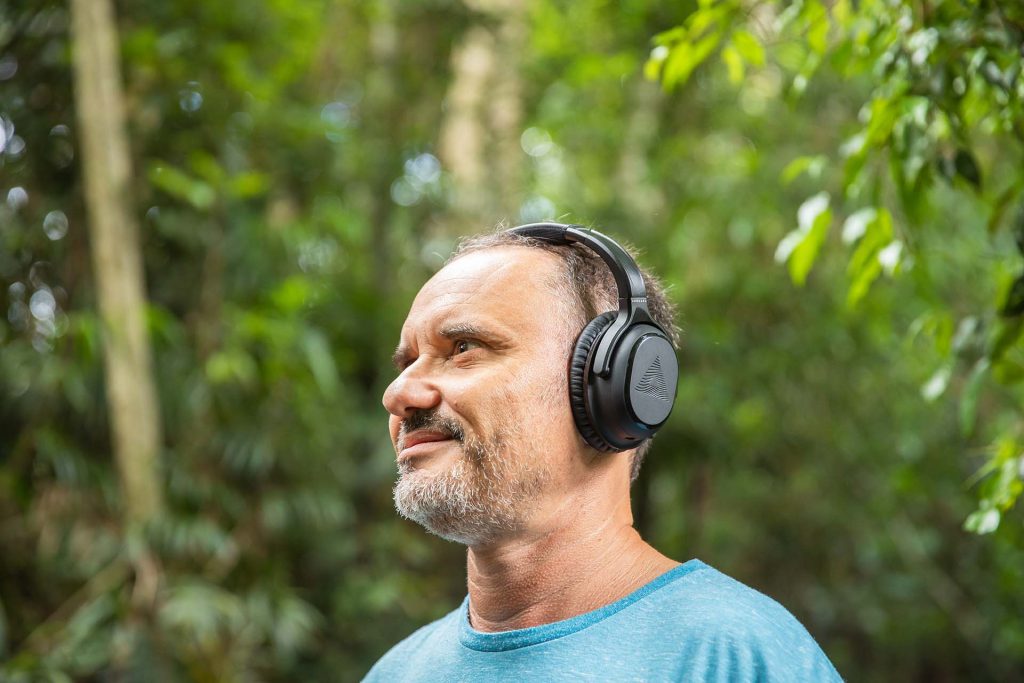 Man wearing over-the-ear headphones outside.