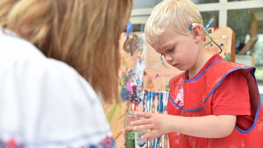 Boy With Hearing Aid Doing Craft