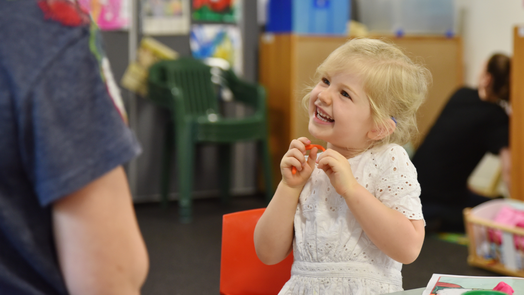 Happy young girl in speech therapy session.