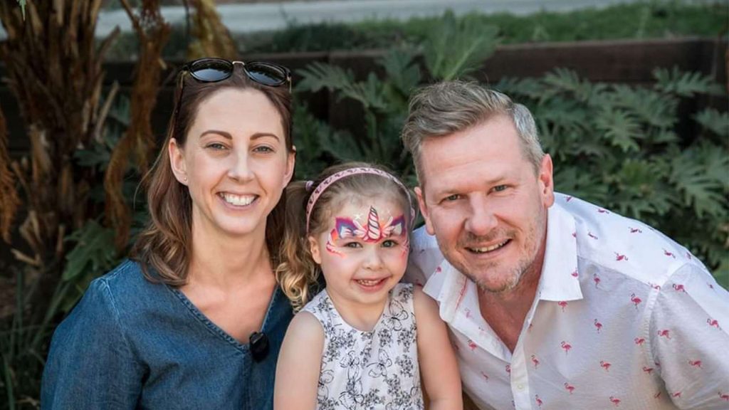 Lady, Child And Man Smiling A Camera