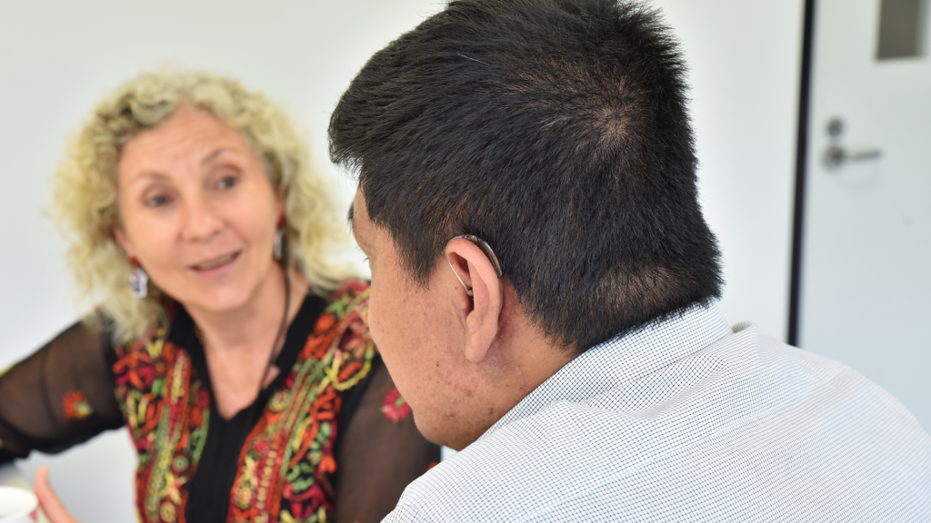 Man with hearing aid talking to clinician.