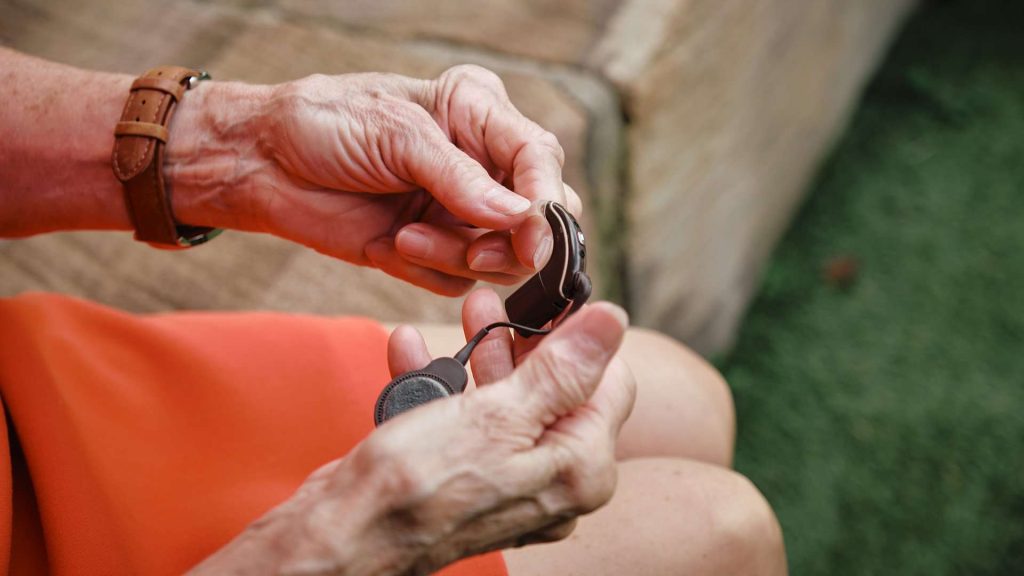 Lady’s hands holding cochlear implant.