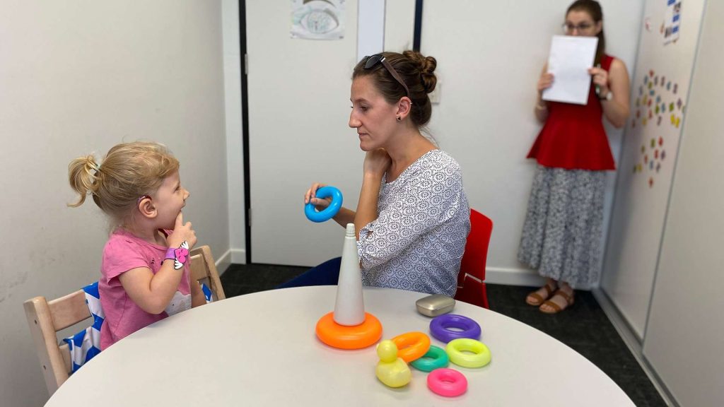 Child in speech therapy session with clinician.