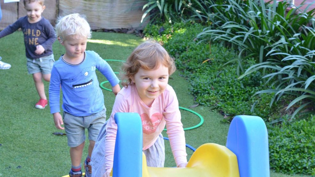 Three Children Playing On Slide