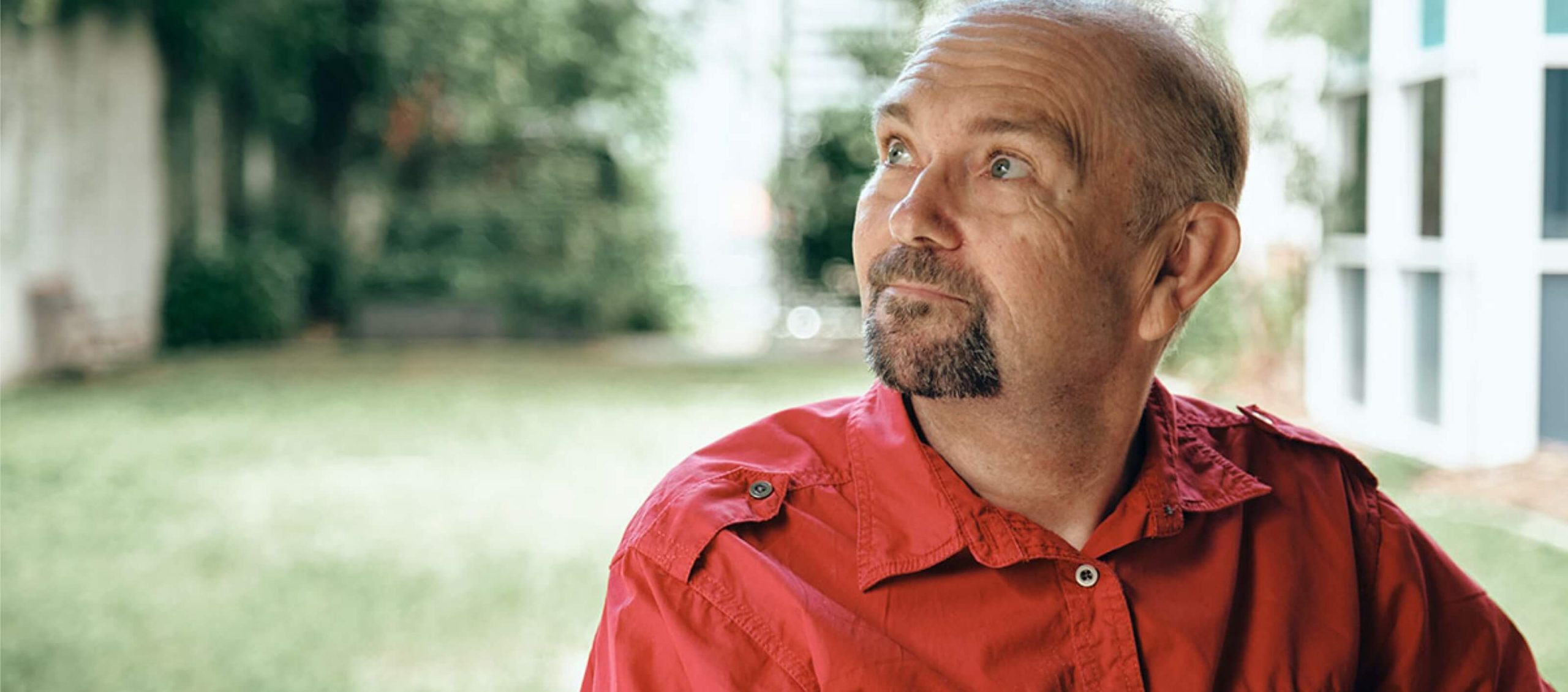 Man in red shirt standing outside